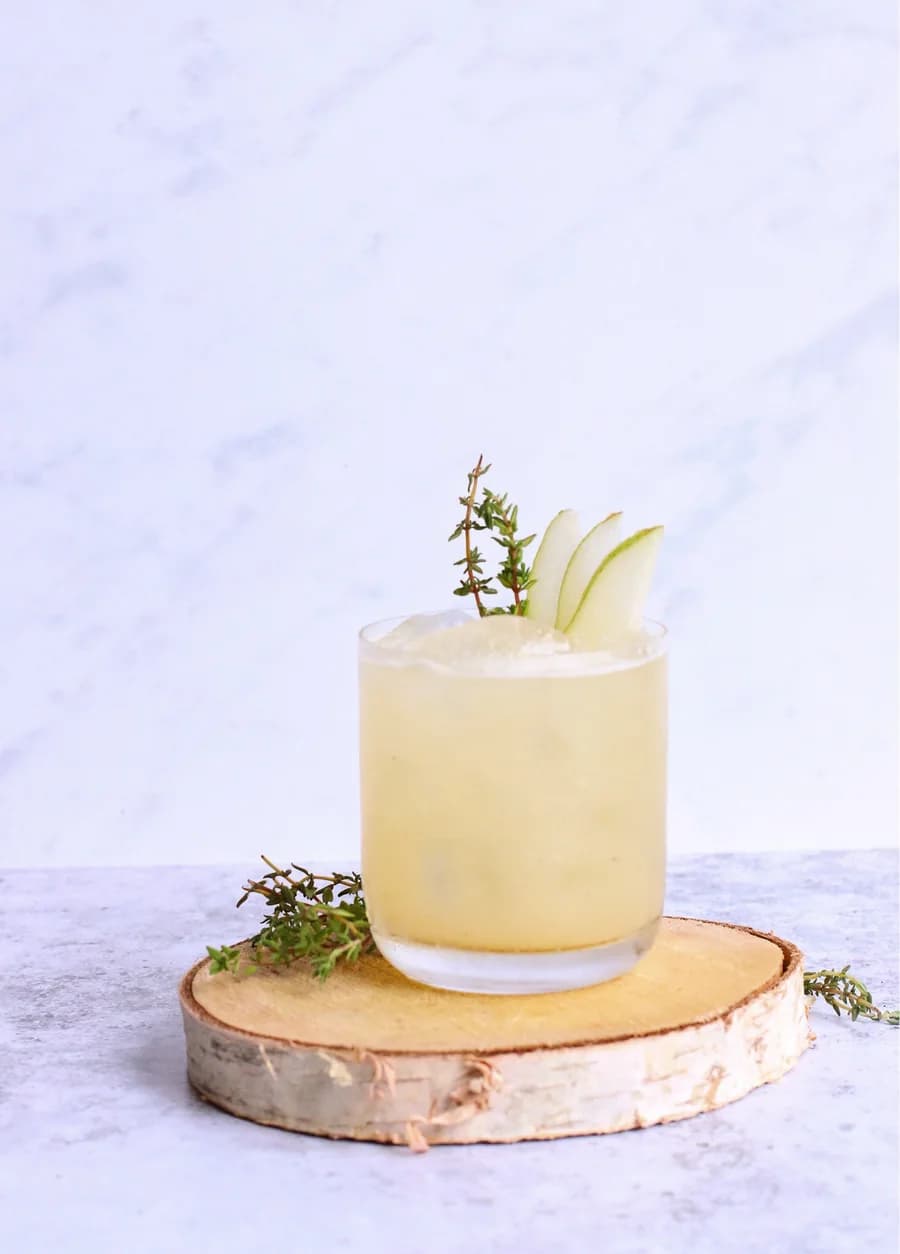A spiced pear and ginger fizz garnished with pear and rosemary